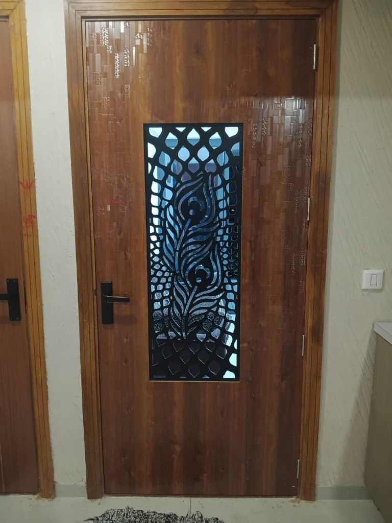 Custom teak wood entrance door with laser-cut peacock motif panel in New Ranip